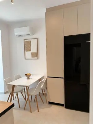 a kitchen with a table and chairs and a refrigerator at Dida stone home in Chania Town