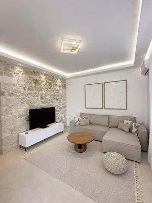 a living room with a couch and a tv at Dida stone home in Chania Town
