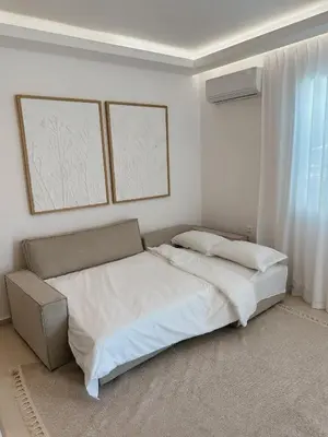 a white bedroom with a bed and a window at Dida stone home in Chania Town