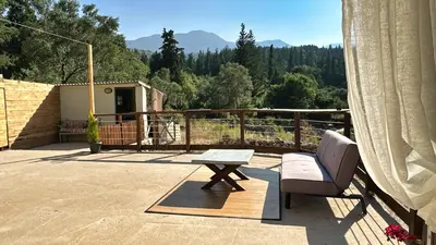 a patio with a table and a chair on a deck at The Root House - Crete Stay in Vafés