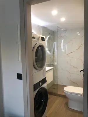 a bathroom with a washing machine and a toilet at Casa del Sol - Kalathas in Kalathas