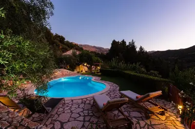 a swimming pool with two lounge chairs and a swimming pool at Vrisali Traditional Stone Villa in Gerolakkos