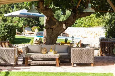a patio with a couch and chairs and an umbrella at Vrisali Traditional Stone Villa in Gerolakkos