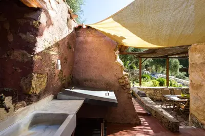 a bathroom with a sink in a stone wall at Vrisali Traditional Stone Villa in Gerolakkos