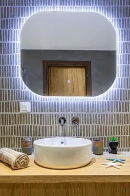 a bathroom with a sink and a mirror on a counter at Seatherial Apartments Paleochora in Palaiochóra