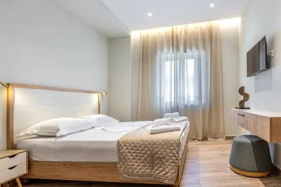 a bedroom with a large bed and a window at Seatherial Apartments Paleochora in Palaiochóra