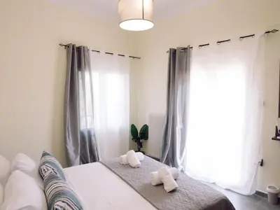 a bedroom with two towels on a bed with a window at Chania Charming Nest in Chania Town