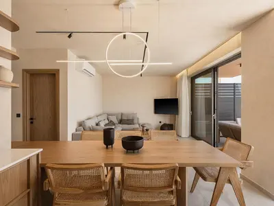 a dining room and living room with a table and chairs at Onora Villa - Steps from the Sea by etouri in Nopíyia