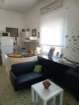 a kitchen and a living room with a couch and a table at Veranda with endless view in Fournés