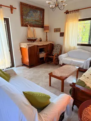 a living room with two beds and a table at Retro Groove in Palaiochóra