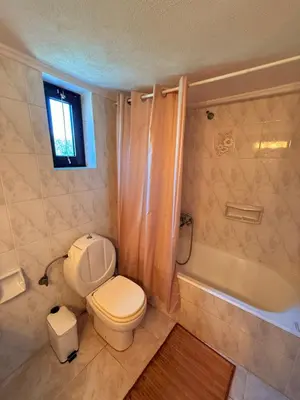 a bathroom with a toilet and a bath tub at Retro Groove in Palaiochóra