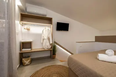 a small room with a bed and a tv at Aladdin Luxury Suites With Shared Pool in Galatás