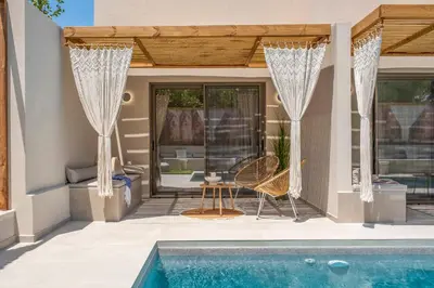 a house with a swimming pool and a patio at Aladdin Luxury Suites With Shared Pool in Galatás