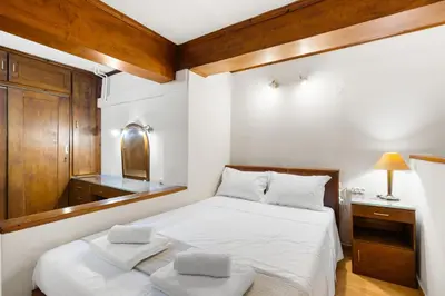 a small bedroom with a bed and a mirror at Spitatsi - Home with Yard in Chania Town