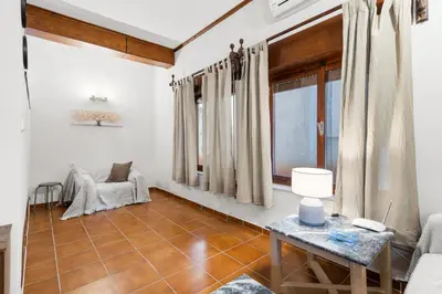 a living room with a table and a window at Spitatsi - Home with Yard in Chania Town