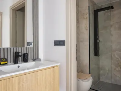 a bathroom with a toilet and a sink and a shower at Lum Urban Suites in Chania Town