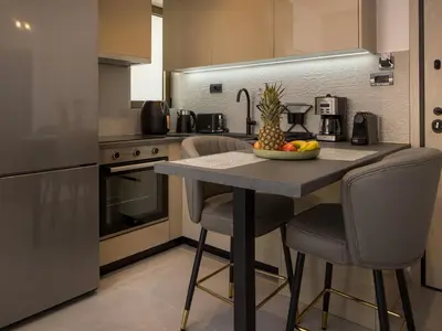 a kitchen with a table with a bowl of fruit on it at Lum Urban Suites in Chania Town