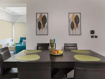 a dining room table with chairs and a bowl of fruit at Lum Urban Suites in Chania Town