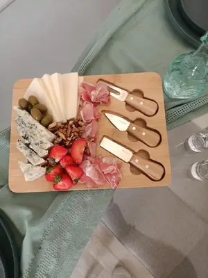 a cutting board with cheese and fruit on a table at Menta Apartment's in Maleme