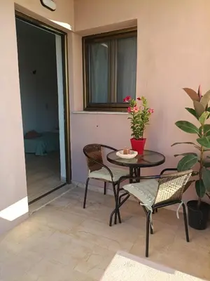 a patio with a table and chairs and a window at Menta Apartment's in Maleme