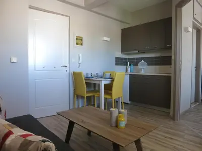 a kitchen with a table and yellow chairs in a room at Pantheon Aparthotel in Chania Town