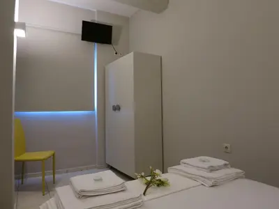 a room with a white cabinet and towels on a bed at Pantheon Aparthotel in Chania Town