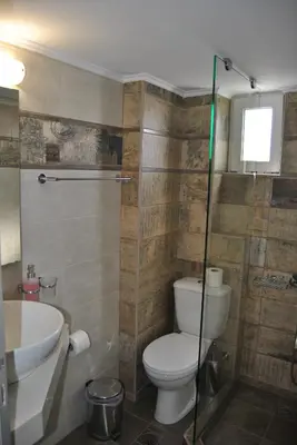 a bathroom with a toilet and a sink and a shower at Pantheon Aparthotel in Chania Town