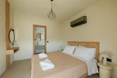 a bedroom with a bed with two towels on it at Madre Tierra Boutique Villa 3 in Potistíria