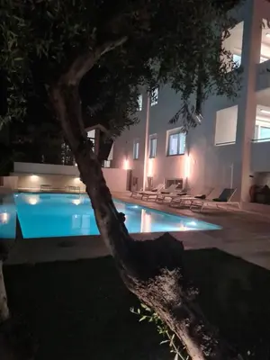 a pool in front of a building at night at Andreas Villa in Kato Daratso