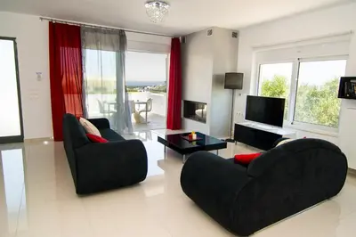 a living room with two chairs and a television at Andreas Villa in Kato Daratso