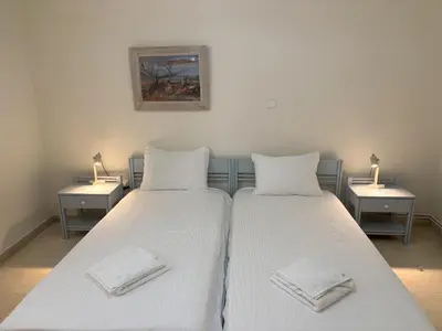 two beds with white pillows in a room at Orange Tree in Chania Town