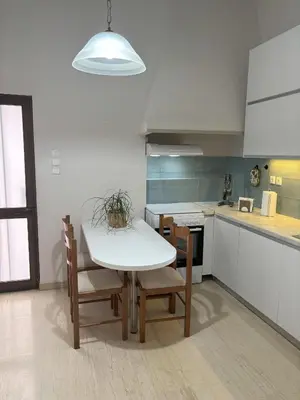 a kitchen with a white table and chairs in a kitchen at Orange Tree in Chania Town