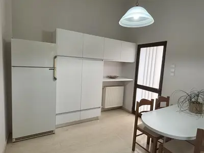 a kitchen with a white refrigerator and a table at Orange Tree in Chania Town