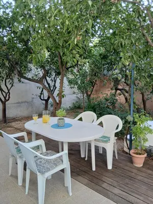 a white table and chairs on a deck with trees at Orange Tree in Chania Town