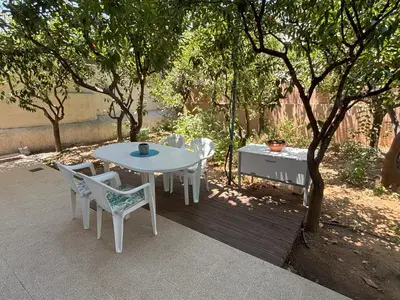 a table and chairs on a patio under a tree at Orange Tree in Chania Town