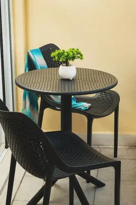 a table and two chairs with a potted plant on it at ES Apartments ARION in Chania Town