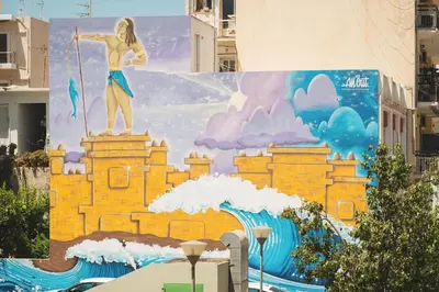 a mural on the side of a building with a statue of a man on top at ES Apartments ARION in Chania Town