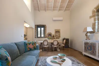 a living room with a blue couch and a table at Villa Manmar 2BR with Sleeping Lofts by etouri in Spiliá