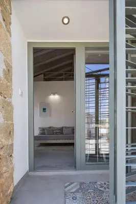 a glass door leading into a room with a couch at Villa Manmar 2BR with Sleeping Lofts by etouri in Spiliá