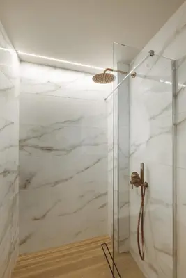 a shower with marble walls and a glass door at Madre Tierra Boutique Villa 4 in Potistíria