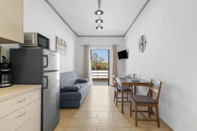 a kitchen and dining room with a refrigerator and a table at Seafront Apartment in Chania 6 in Chania Town