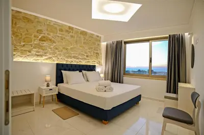 a bedroom with a large bed with a stone wall at Koukis Villa With Sea View in Falasarna