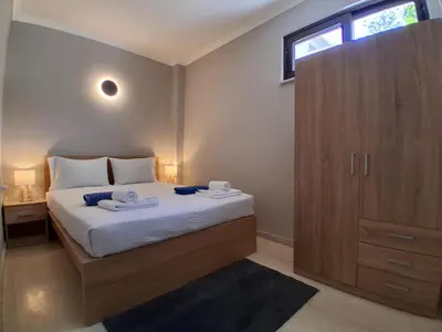 a bedroom with a bed and a wooden cabinet at Diotima apartment in Chania Town
