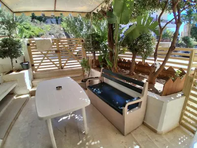 a bench and a table on a patio with trees at Diotima apartment in Chania Town