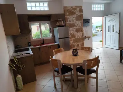 a kitchen with a table and chairs and a refrigerator at Despoinas House in Plátanos