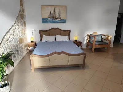 a bedroom with a large bed and a chair at Despoinas House in Plátanos