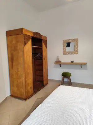 a bedroom with a wooden cabinet next to a bed at Despoinas House in Plátanos