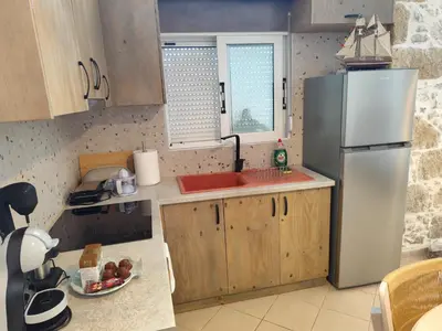 a kitchen with a stainless steel refrigerator and wooden cabinets at Despoinas House in Plátanos