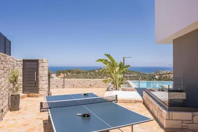 a ping pong table on the patio of a house at Sky Sea View Villas in Chania Town