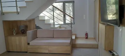 a living room with a couch and a staircase at Casa di Laino in Kounoupidhianá